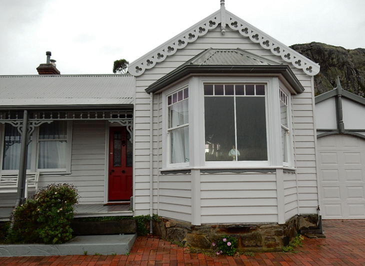 Historic home with decorative trim and a visible stone foundation.