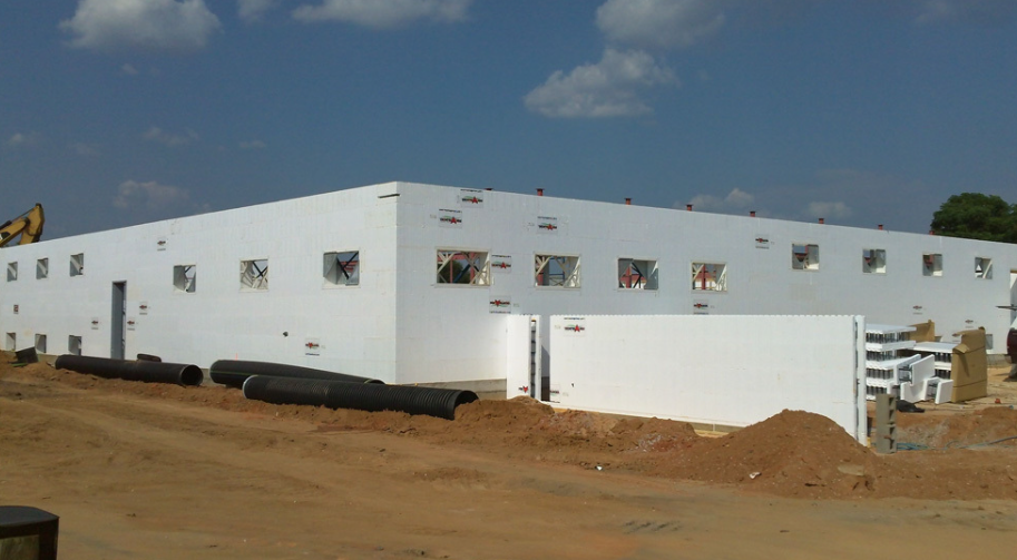 Building under construction using Fox Blocks insulated concrete form (ICF) walls, with window openings visible.